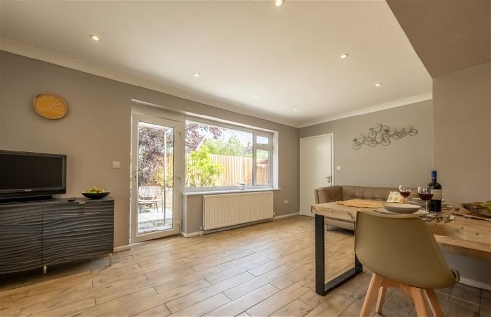 Open-plan kitchen/dining area with sofa and Smart television at 8 Town Close, Holt