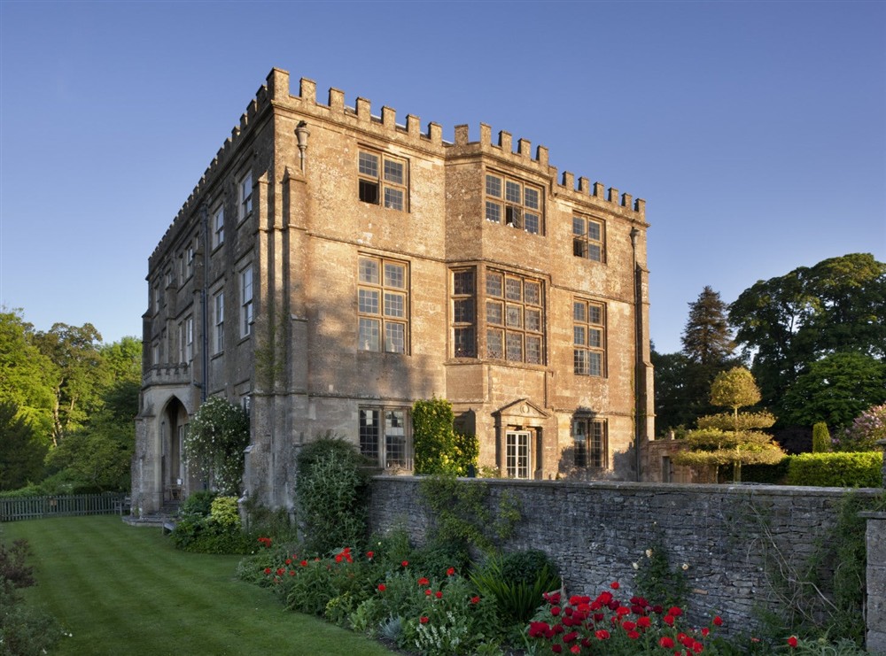 The house cast in sunset light with flowers growing in the borders at 9 Arlington Row in Cirencester, Gloucestershire