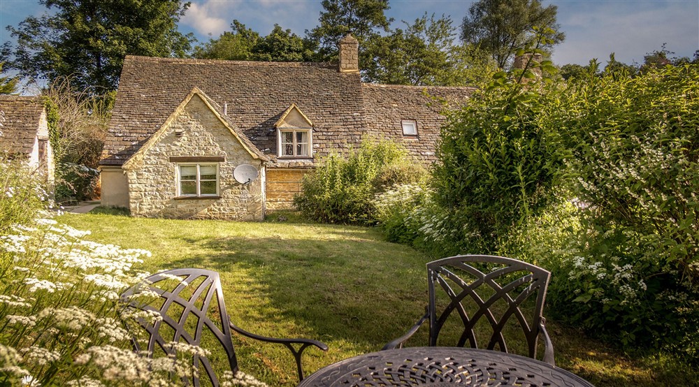 The rear garden with lawn and flower beds at 9 Arlington Row in Cirencester, Gloucestershire