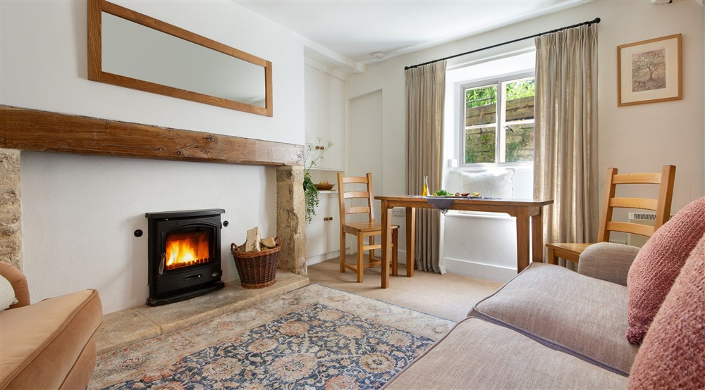 The sitting and dining room with woodburner at 9 Arlington Row in Cirencester, Gloucestershire
