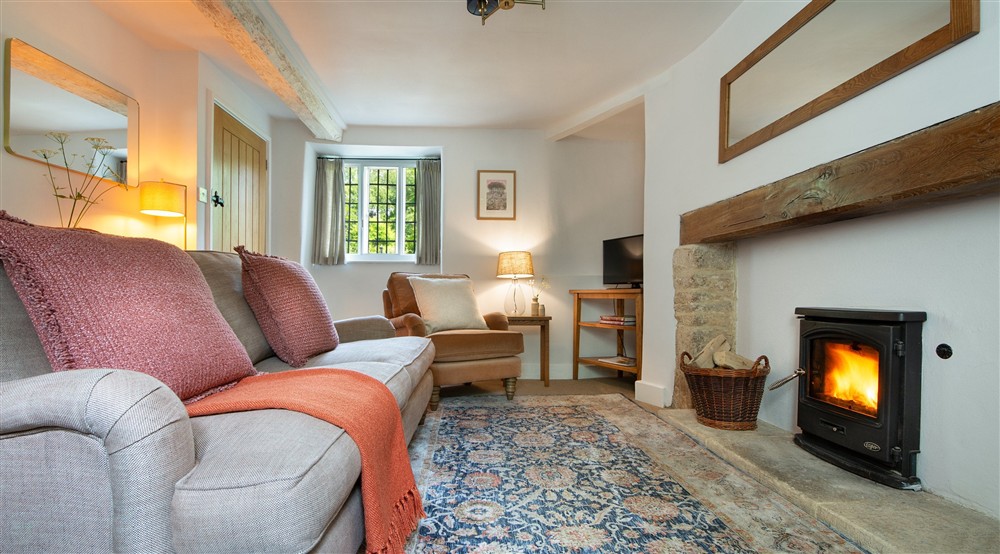 The sitting room with sofa, armchair, television and woodburner at 9 Arlington Row in Cirencester, Gloucestershire