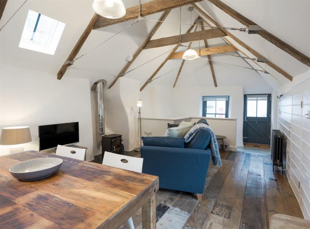 Open plan living space with original distressed solid wooden floors, high apex ceiling and beams at 9 Chapel Street in Mousehole, near Penzance, Cornwall
