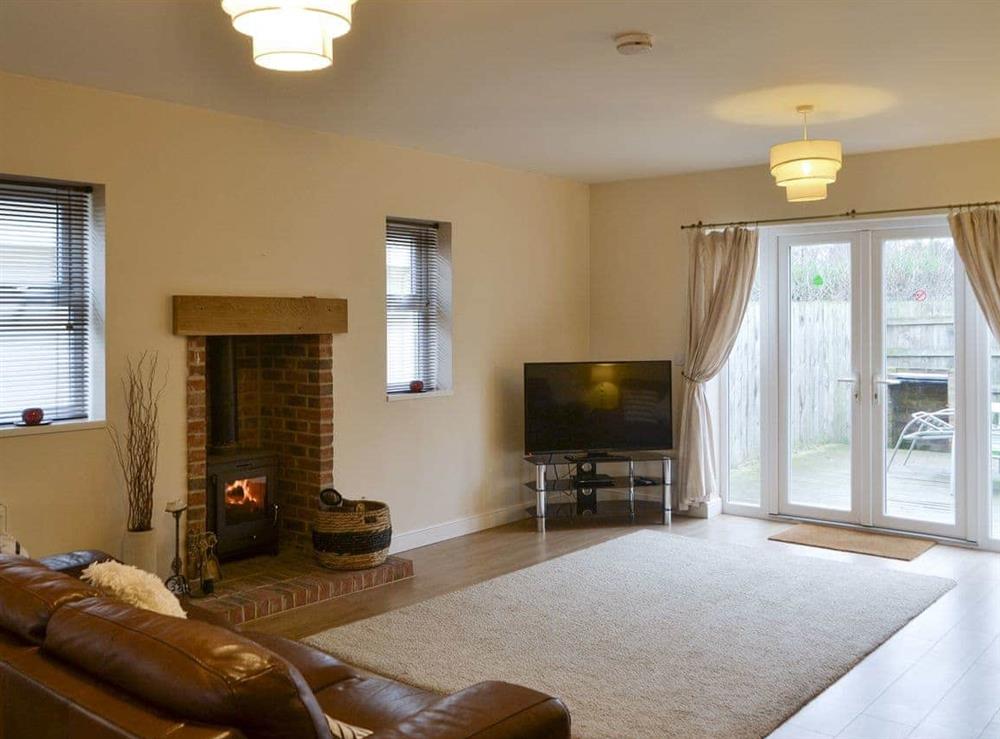 Welcoming living area with wood burner at Abbey Cottage in Longhirst, near Morpeth, Northumberland