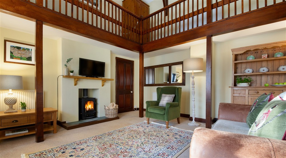 The sitting room with wood burning stove and television at Abbey Stores in Ripon, North Yorkshire