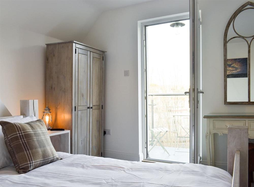 Peaceful double bedroom with door to balcony at Abbey View in Whitby, Yorkshire, North Yorkshire