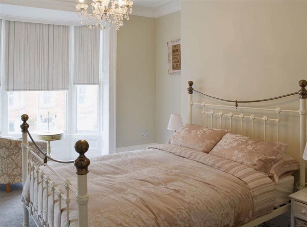 Master bedroom with antique style king size double bed at Abbeydale Town House in Whitby, North Yorkshire