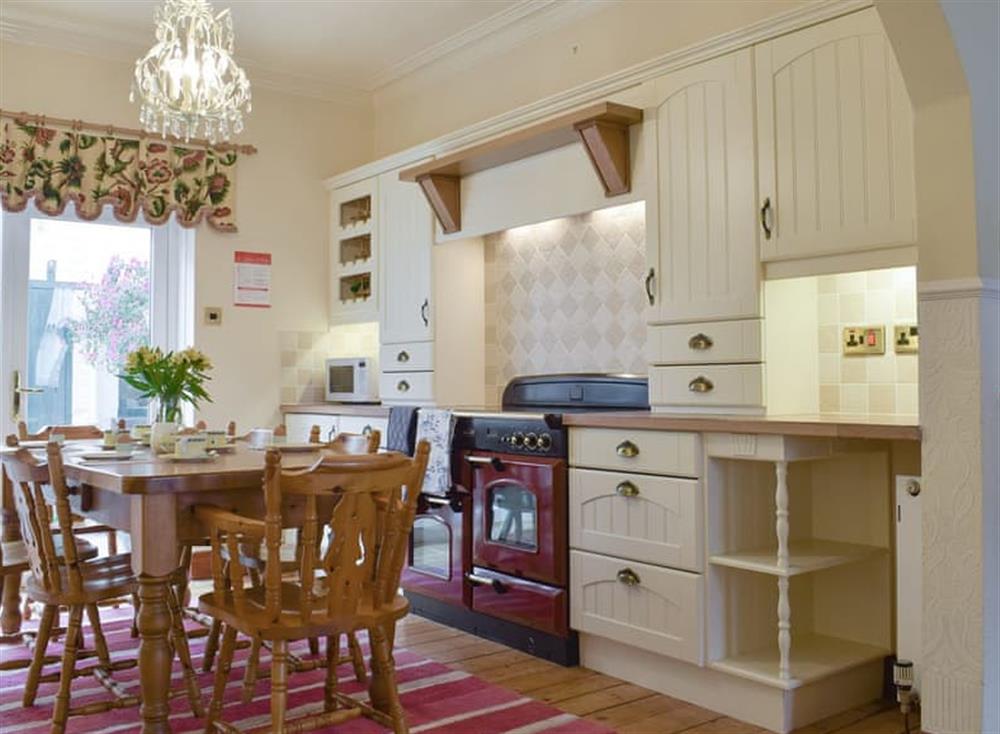 Fully equipped kitchen and dining area with French doors to courtyard garden at Abbie House in St Monans, Fife