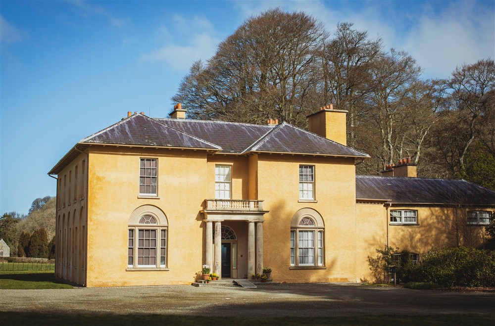 A white Georgian villa with a sweeping drive and green lawn to the front at Abermydyr in Aberaeron, Ceredigion