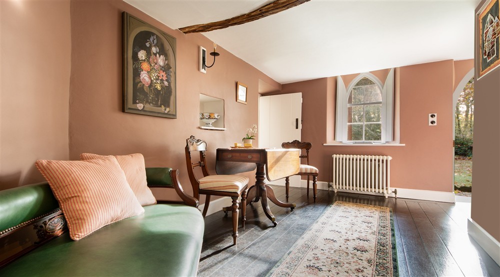 Room with a small dining table and chaise lounge, leading to the ground-floor twin bedroom at Abermydyr in Aberaeron, Ceredigion
