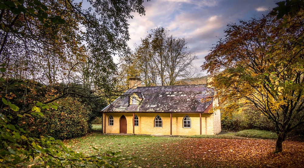 The exterior of Abermydyr, surrounded by trees and lawned garden, Ceredigion at Abermydyr in Aberaeron, Ceredigion