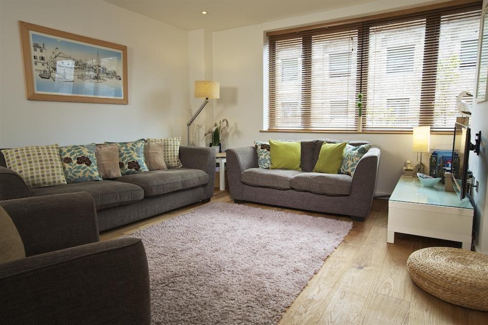 Living area with three and two seater sofas and a single swivel chair at About Tide in , Dartmouth