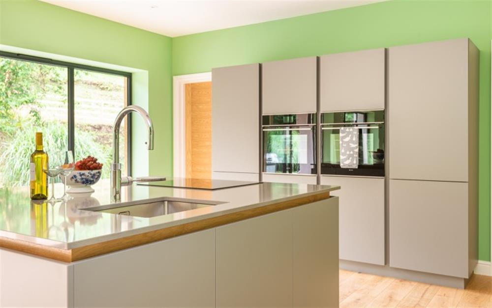 Contemporary fitted kitchen with central island at Acacia House in Cornworthy