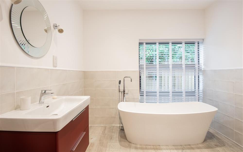 Downstairs family bathroom with freestanding bath at Acacia House in Cornworthy
