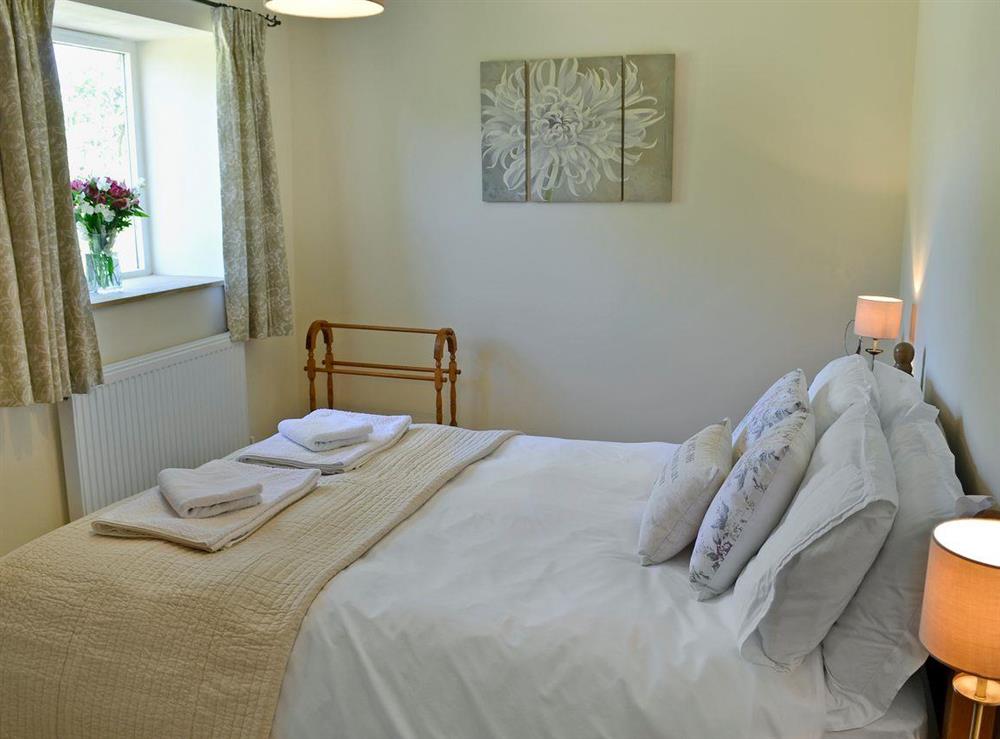 Charming double bedroom with kingsize bed at Acorn Cottage in North Perrott, near Crewkerne, Somerset