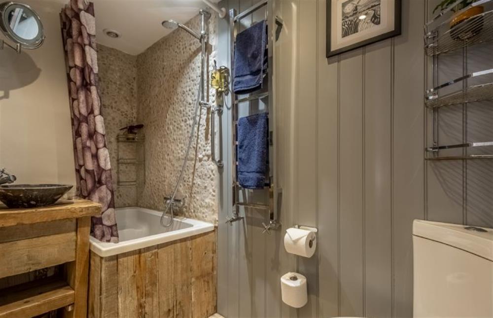 First floor: En-suite bathroom to bedroom to with bath tub with shower over at Acorn Cottage, Tattersett near Kings Lynn