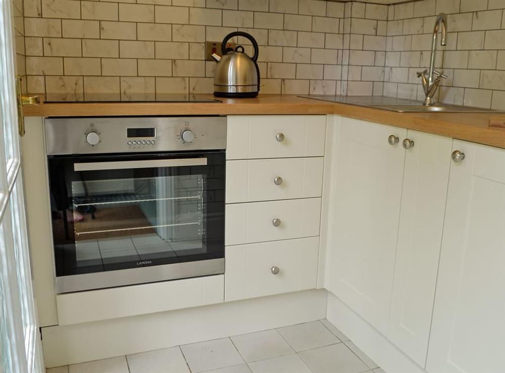 Kitchen with electric oven, electric hob and fridge at Acorn Cottage in Todenham, near Moreton-in-Marsh, Gloucestershire