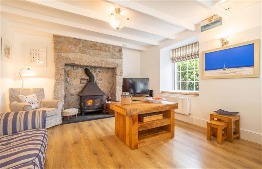 Sitting room with a wood burning stove and flatscreen television at Adanac, Sennen Cove