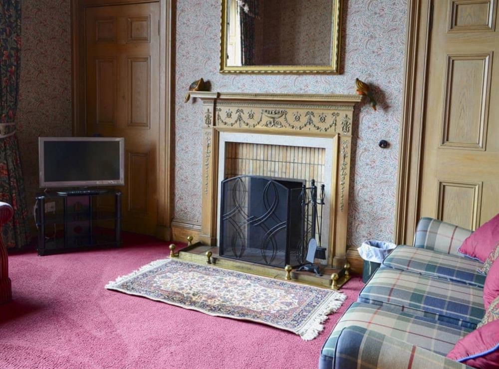 Snug with open fire and TV at Akeld Manor House in Akeld, Wooler, Northumberland., Great Britain