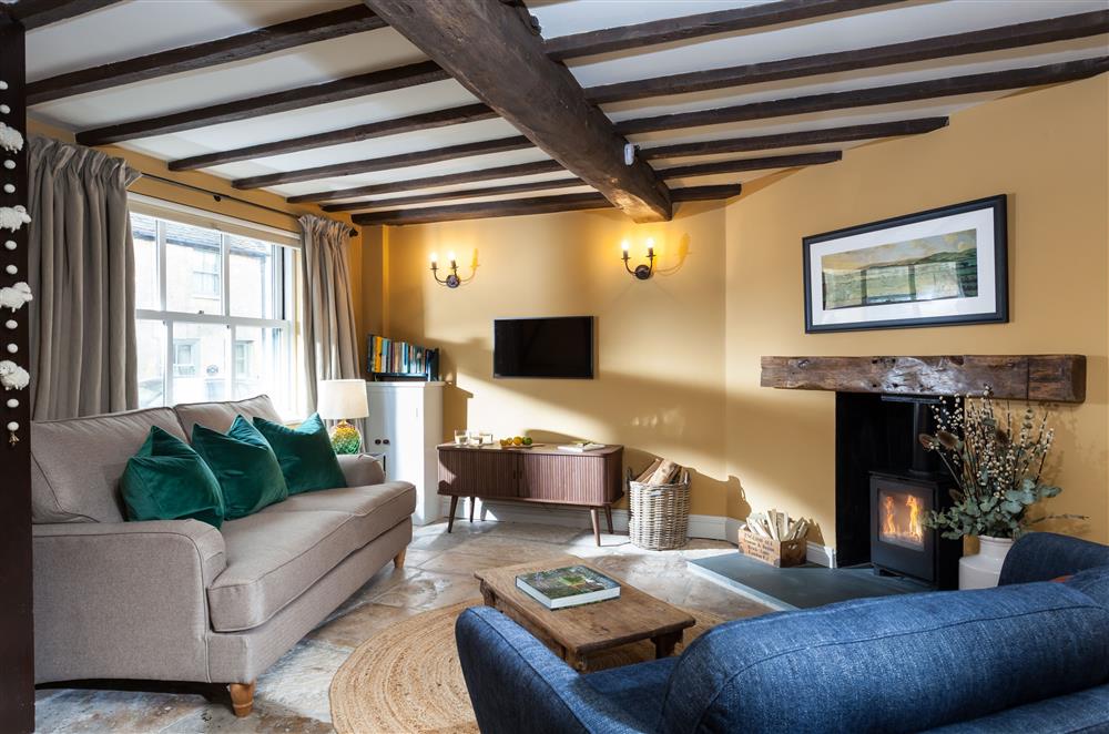 Sitting room with exposed beams and bathed in natural light at Alder Cottage, Winchcombe