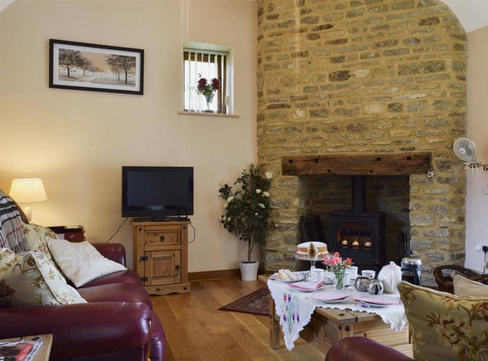 Beamed living room with wood-burning stove at Alfie’s Barn in Ambrosden, Oxfordshire., Great Britain
