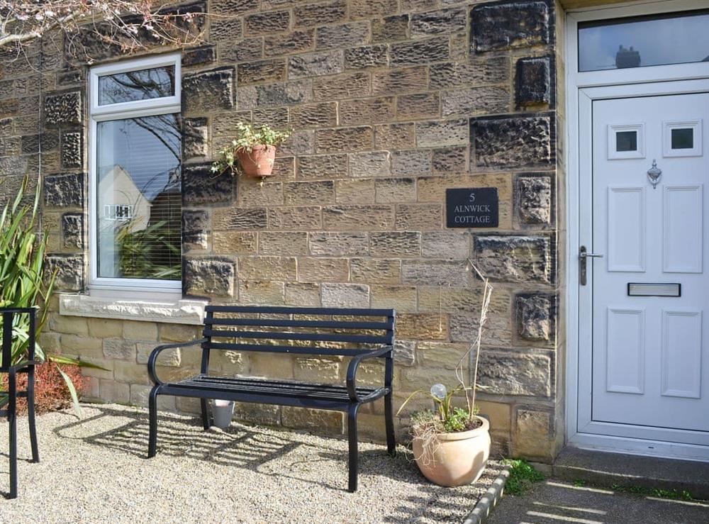 Beautiful gravelled front garden with iron bench at Alnwick Cottage in Alnwick, Northumberland
