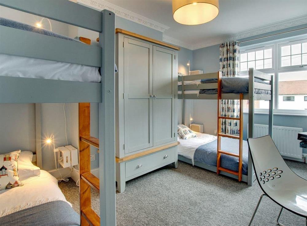 Spacious bedroom with two sets of bunk beds at Amber Waves in Seahouses, near Alnwick, Northumberland