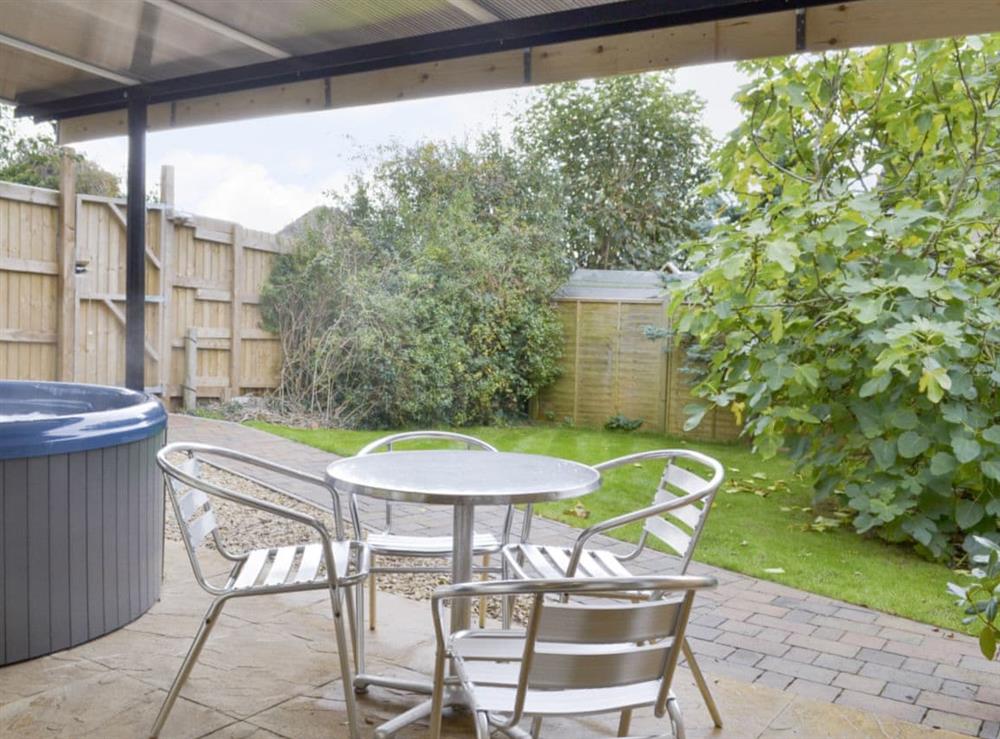 Covered patio with hot tub and outdoor furniture at Amelia Cottage in Clandown, near Radstock, Avon