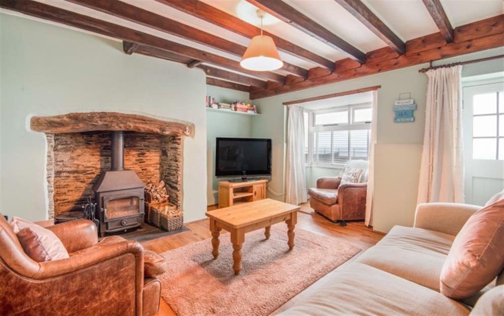 Tastefully furnished lounge with cosy log burner and a bay window to make the most of the view at Anchor Cottage in Beesands