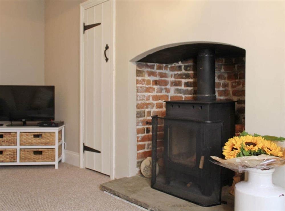 Living room with wood burning stove set in a inglenook fireplace at Anchor Cottage in Deal, Kent