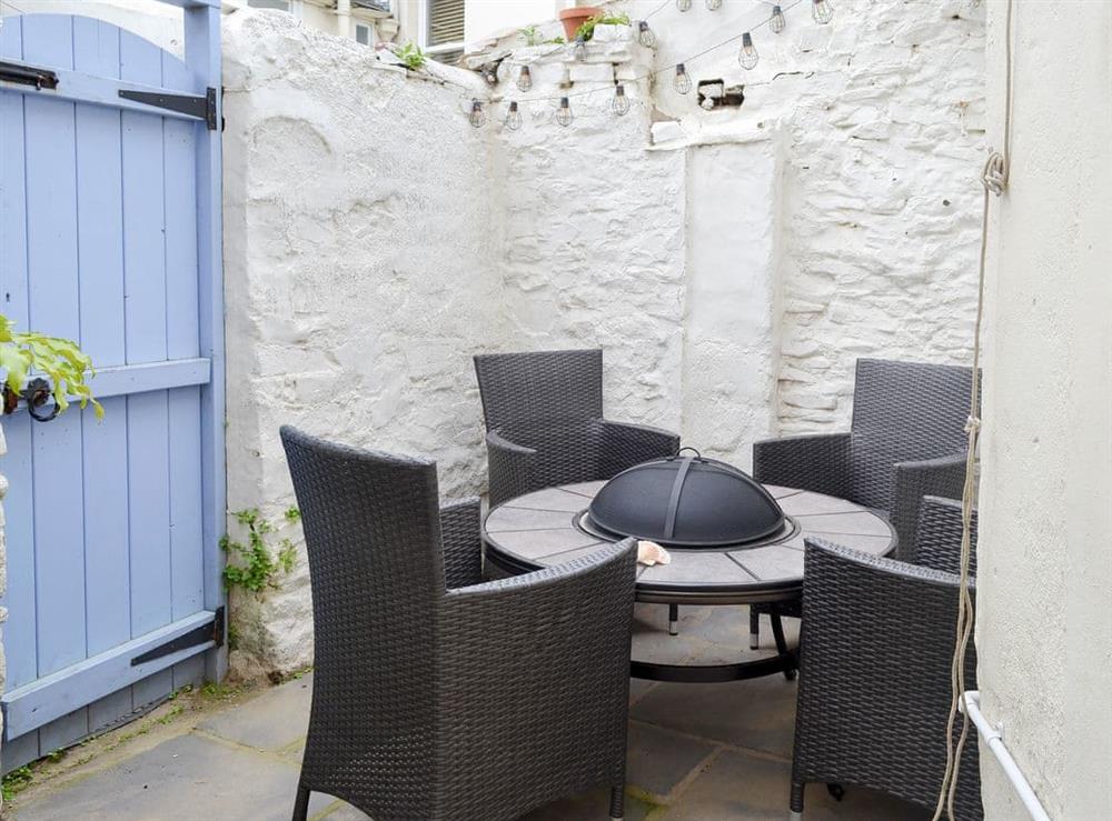 Enclosed courtyard with sitting-out area and firepit at Anchor Cottage in Instow, near Bideford, Devon