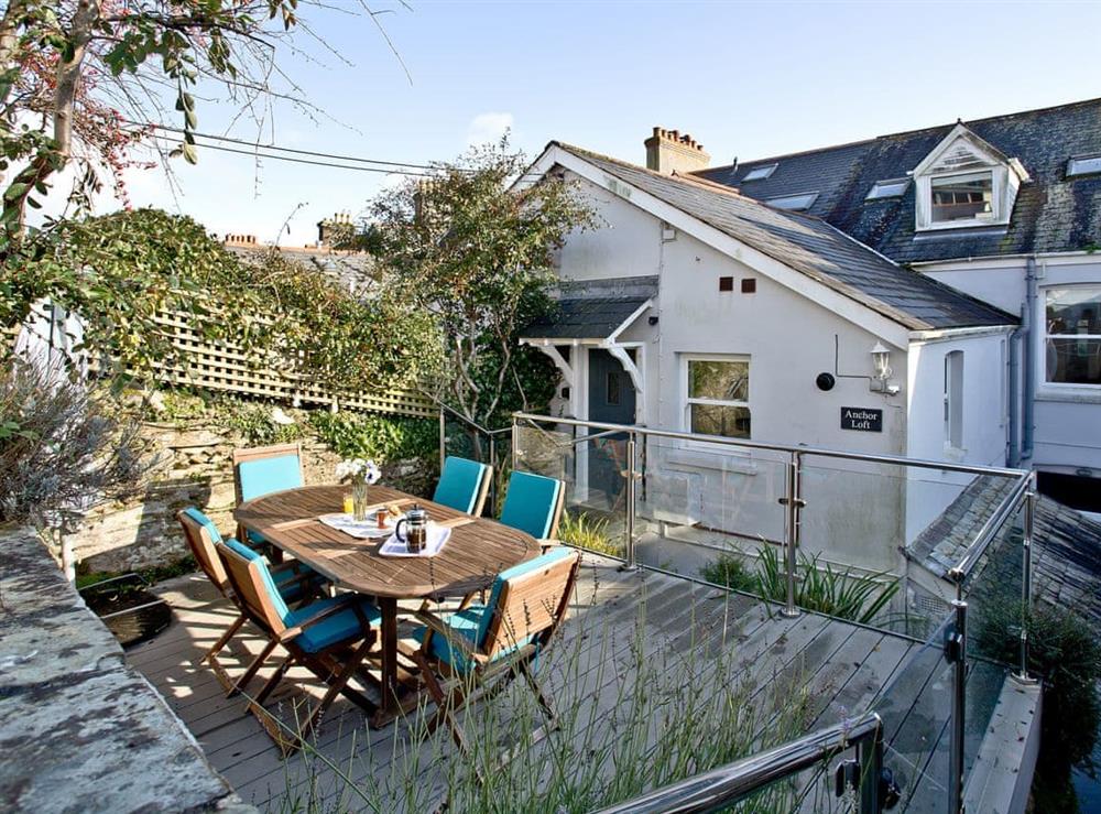 Terraced area with outdoor table and chairs at Anchor Loft in Fowey, Cornwall