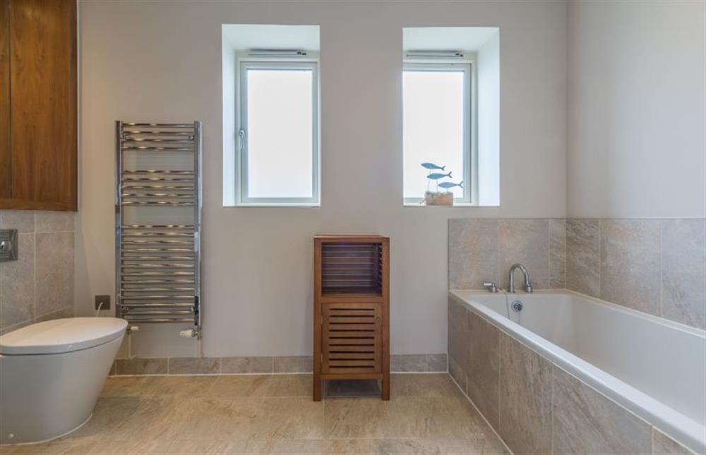 First floor: Bathroom with bath and heated towel rail at Anchorage, Brancaster near Kings Lynn