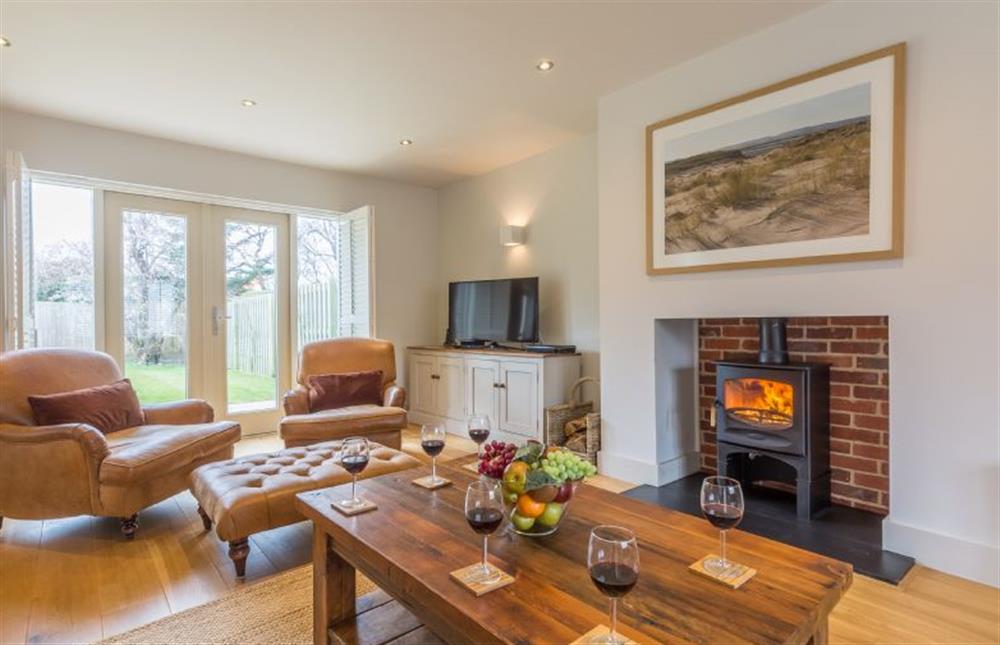 Ground floor: Sitting room with wood burner and leather armchairs at Anchorage, Brancaster near Kings Lynn