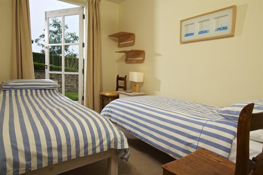 Second twin bedroom with French doors out to the paved terrace and garden at Apartment 3 Combehaven in Allenhayes Road, Salcombe