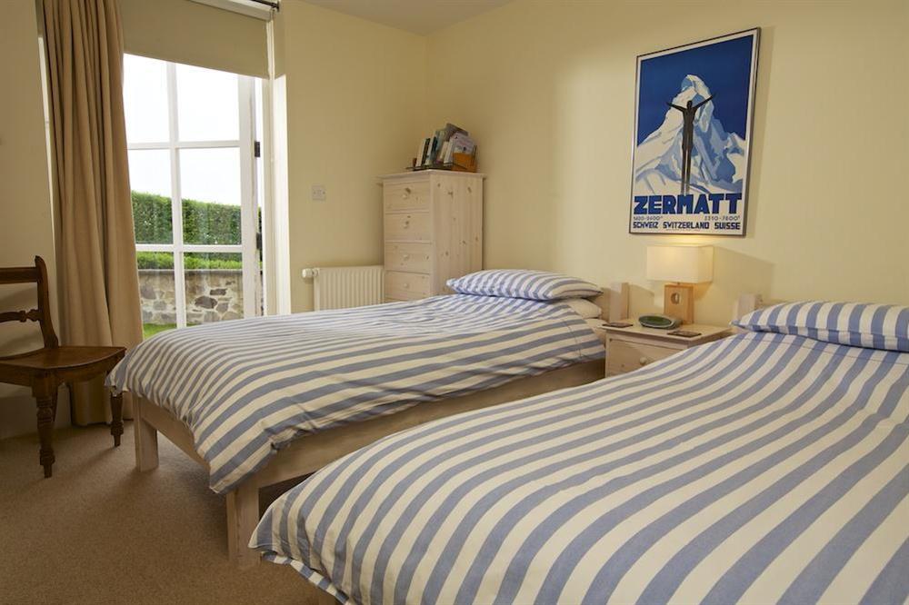 Twin bedroom with French doors out to the paved terrace and garden at Apartment 3 Combehaven in Allenhayes Road, Salcombe
