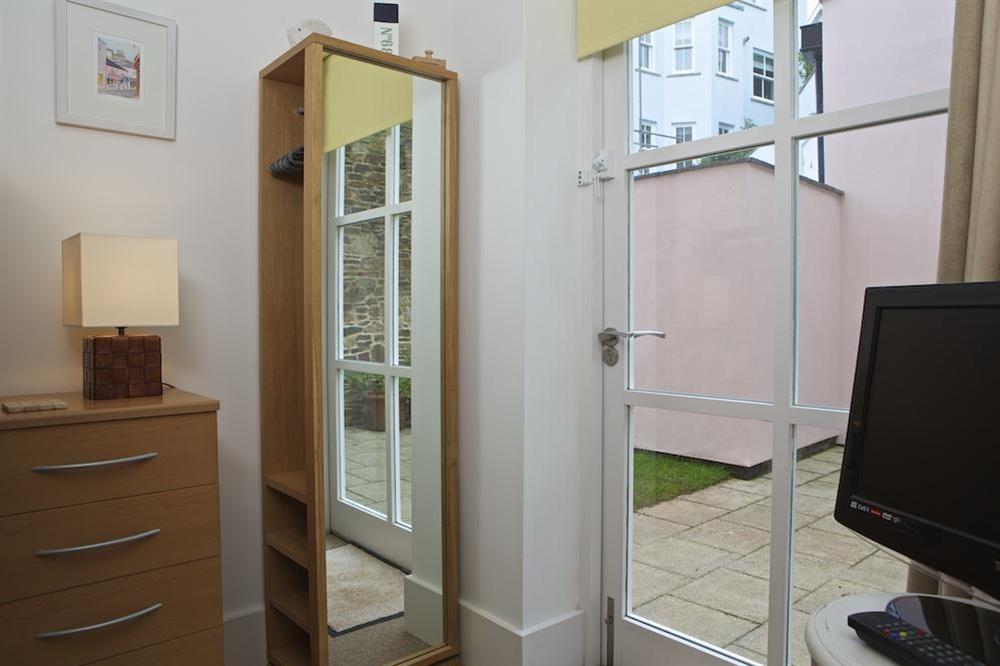 Bunk bedded room with doors leading out to paved side terrace at Apartment 5 Combehaven in Allenhayes Road, Salcombe