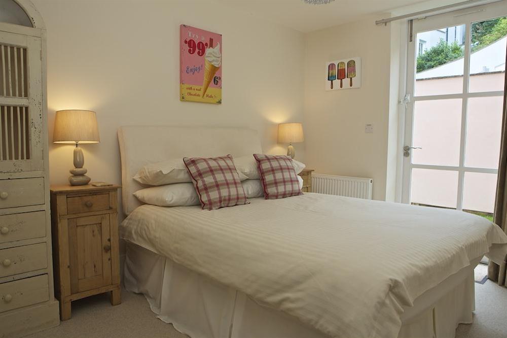 Double bedroom with doors leading out to paved side terrace at Apartment 5 Combehaven in Allenhayes Road, Salcombe