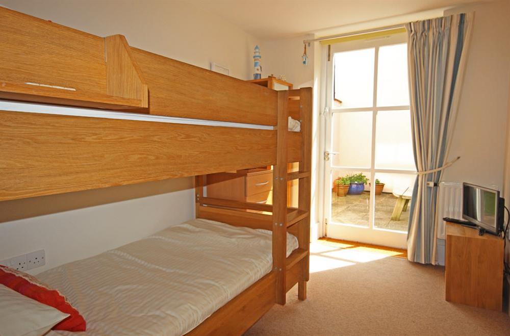 Solid oak bunk beds with doors leading out to paved side terrace