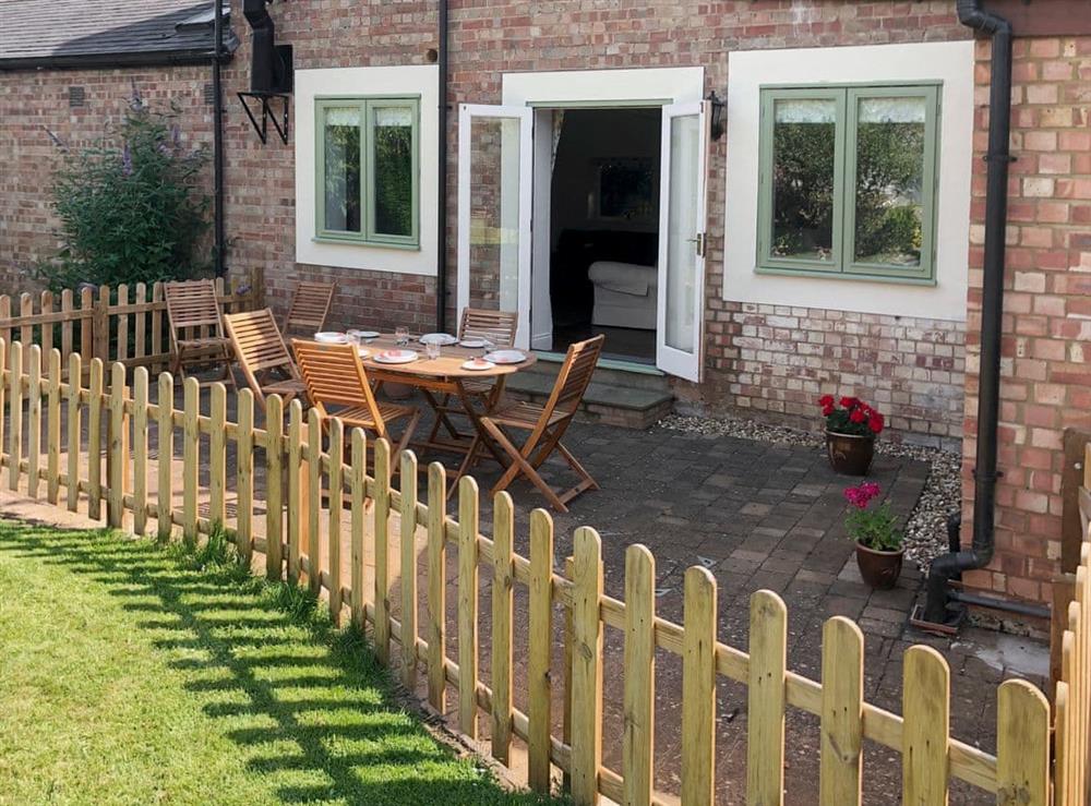 Paved patio with outdoor furniture at Apple Cottage in Spratton, near Northampton, Northamptonshire