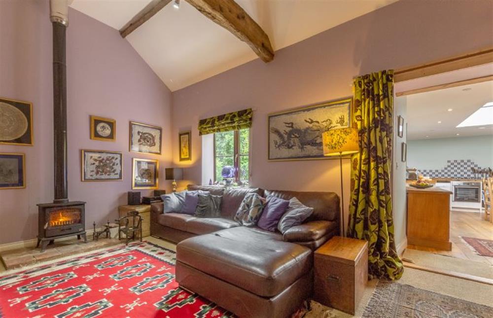 Ground floor:  Sitting room with comfy sofa and wood burning stove at Apple Tree Barn, Langham near Holt