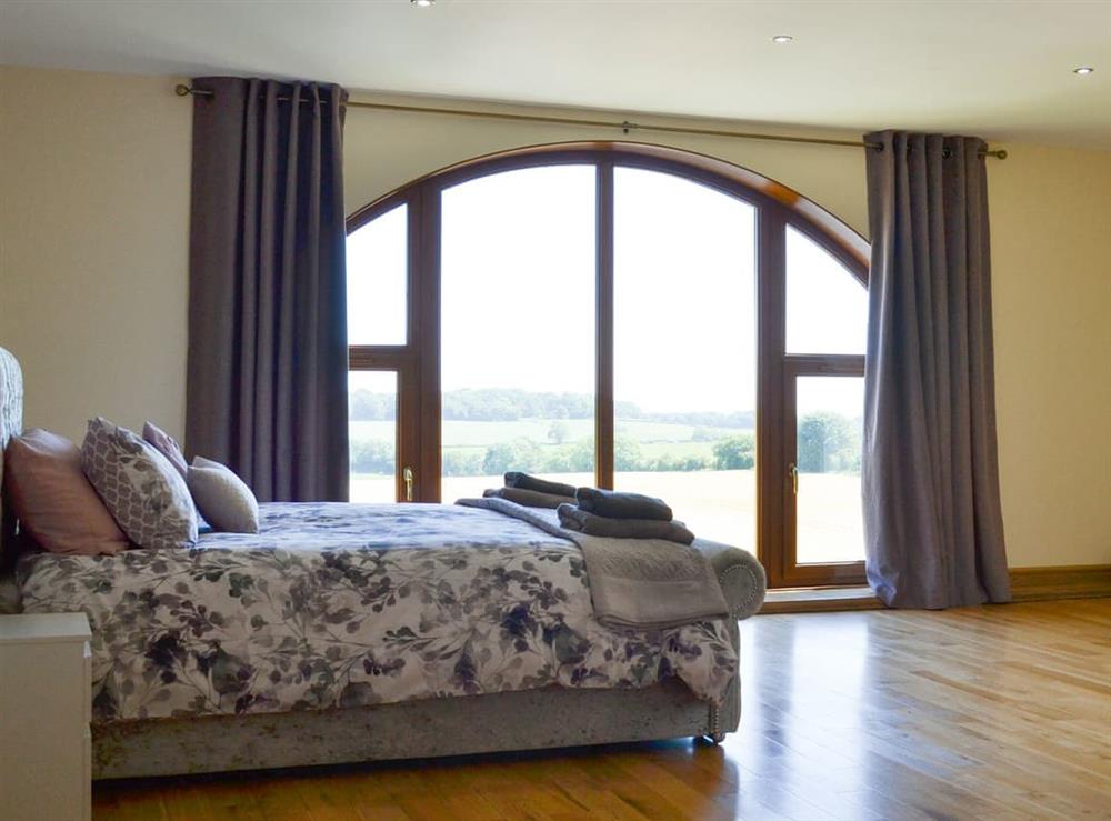fabulous master bedroom with kingsize bed, cot, large picture window, dressing room and large en-suite bathroom at Applegarth House in Howlish, near Bishop Auckland, Durham