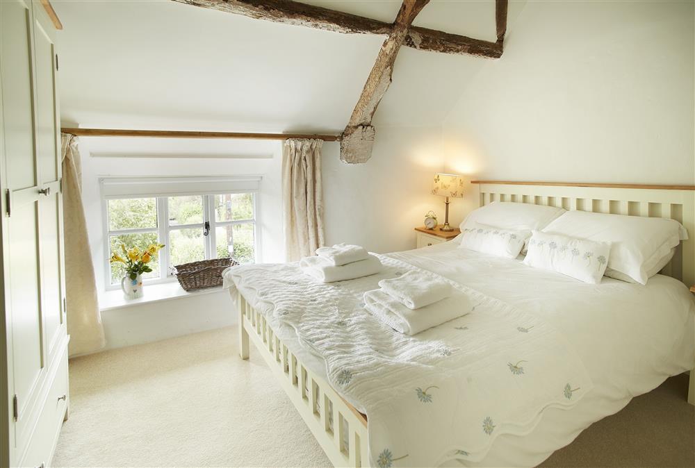 Master bedroom with 5’ king-size bed and vaulted ceiling at Appleyard Cottage, Donhead St Mary