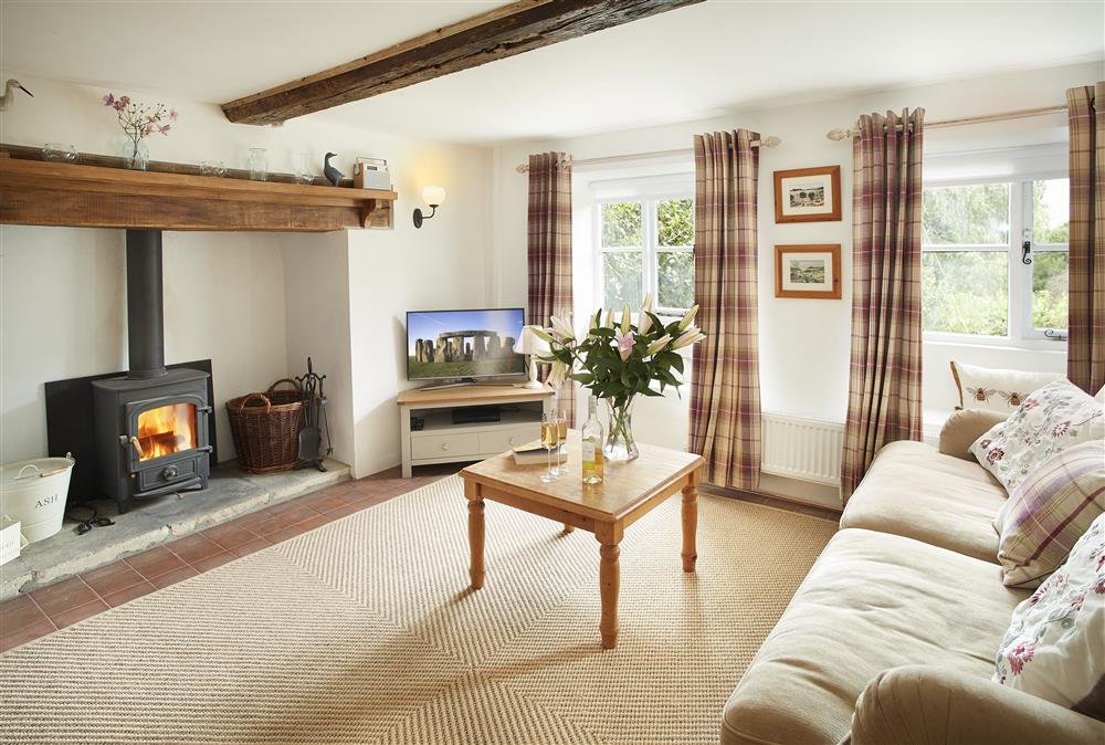 Sitting room with wood burning stove and window seats at Appleyard Cottage, Donhead St Mary