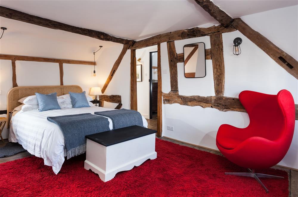 Bedroom one with a 5’ king-size bed and en-suite bathroom at April Cottage, Eckington