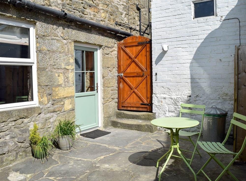 Enclosed patio with garden furniture at April Cottage in Settle, North Yorkshire