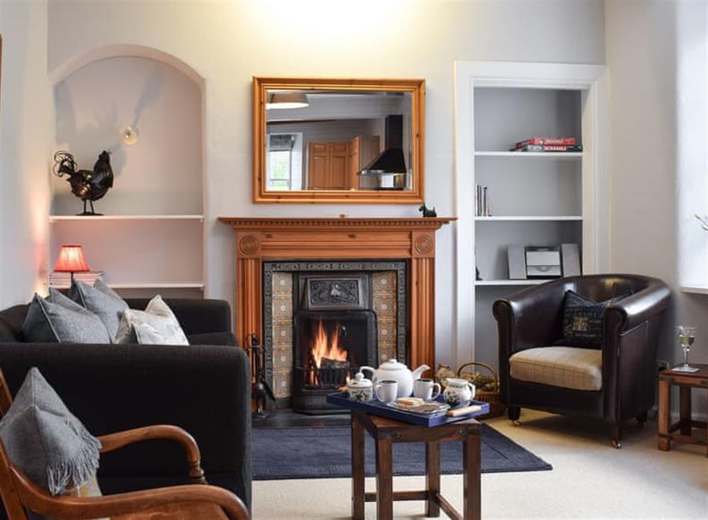 Cosy living room with open fire at Ardchoille Cottage in Fortingall, near Aberfeldy, Perthshire