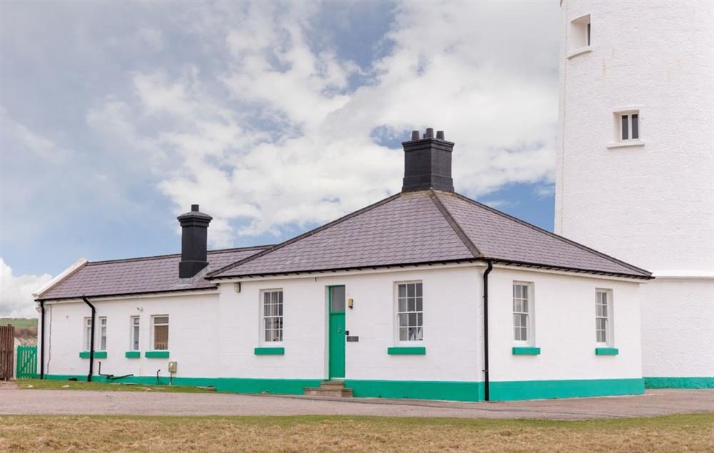 Ariel Cottage is to the left hand side of the tower at Ariel, Nash Point Lighthouse