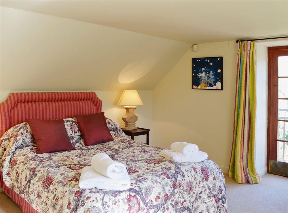 The romantic double bedroom with sloping ceilings and Freench doors to a small balcony at Arkland Mill in Crocketford, near Dumfries., Kirkcudbrightshire