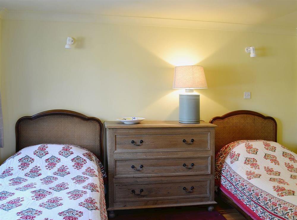 The twin bedded room is furnished with antique beds