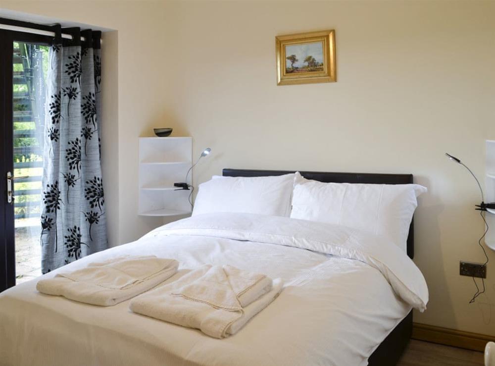 Inviting double bedroom with sliding doors to the garden at Grooms Cottage, 